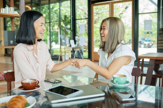 two businesswomen shaking hands local coffee shop two women discussing business projects cafe while having coffee startup ideas brain storm concept using laptop cafe 1150 44737