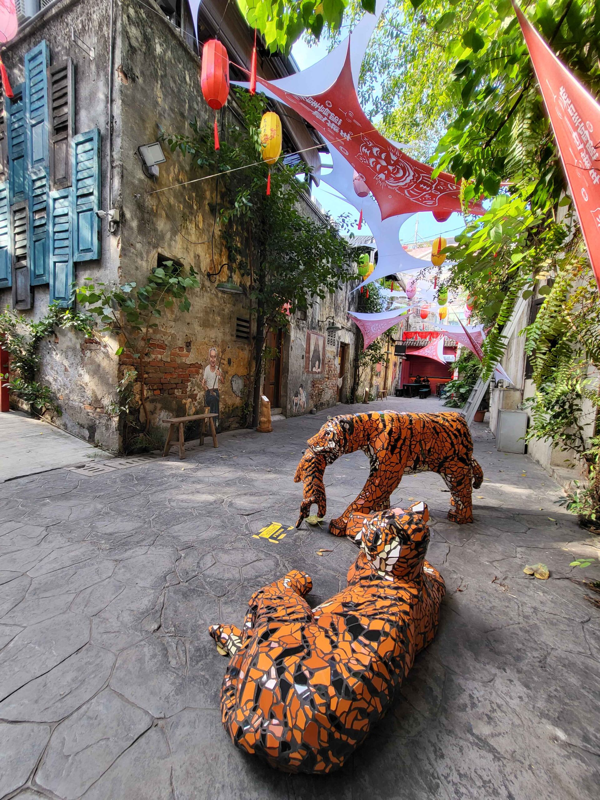 Malayan Tiger Family sculptures front surrounded by Stretch Out fabric installation entire back alley 11zon scaled