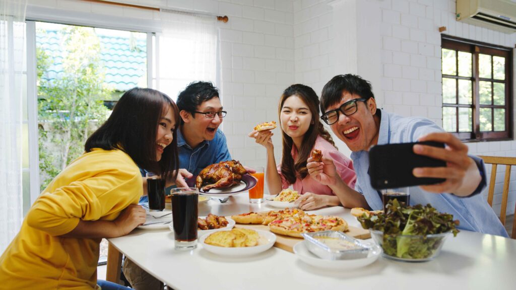 happy young group having lunch home asia family party eating pizza food making selfie with her friends birthday party dining table together house celebration holiday togetherness 11zon