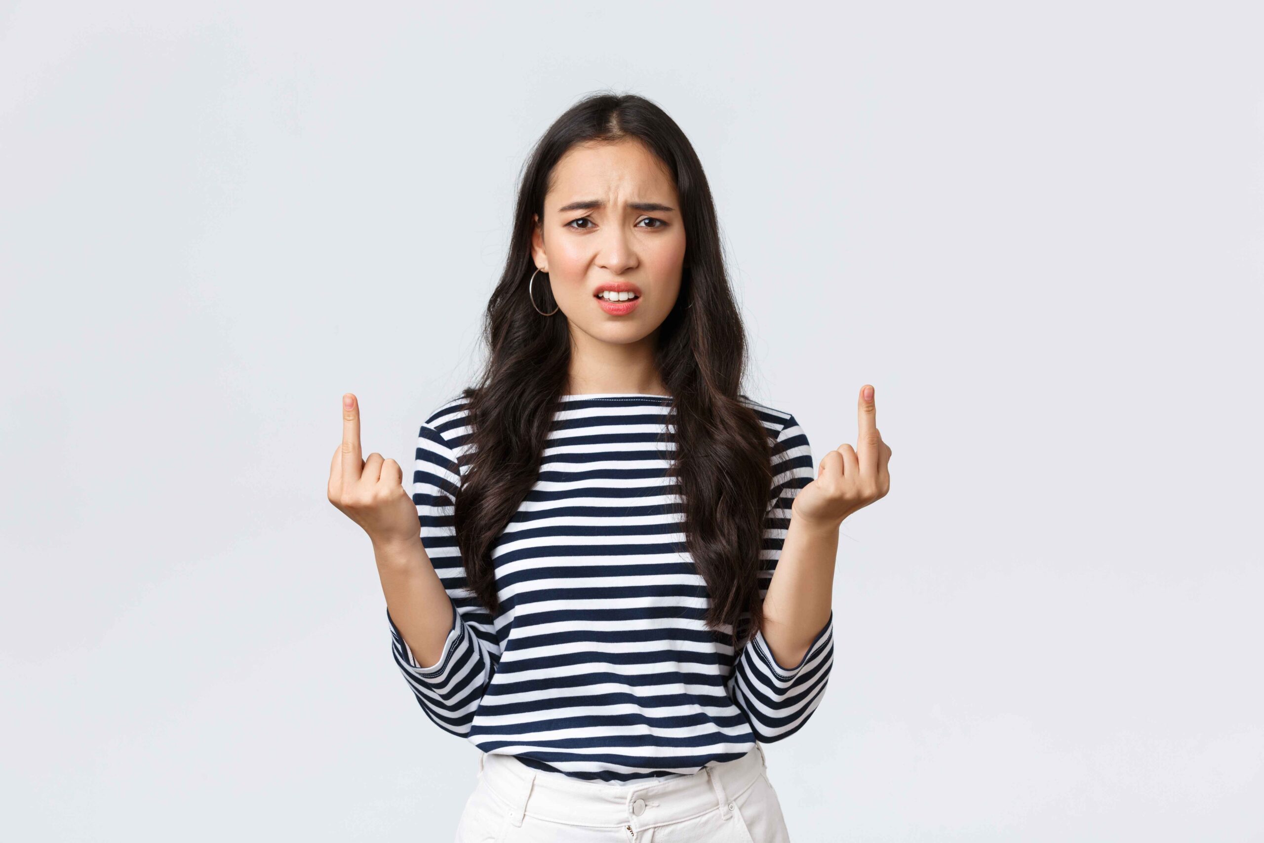 lifestyle beauty fashion people emotions concept annoyed pissed off asian woman stare bothered displeased showing middle fingers careless what people say white background 11zon scaled